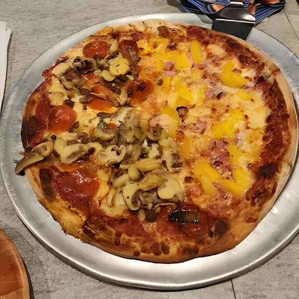 Bruno's Pizzeria pizza with pepperoni, mushrooms, and pineapple on a metal tray.